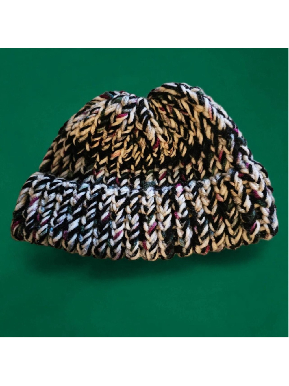 Multi-colored knit beanie with black, white, and pink threads #winteraccessories